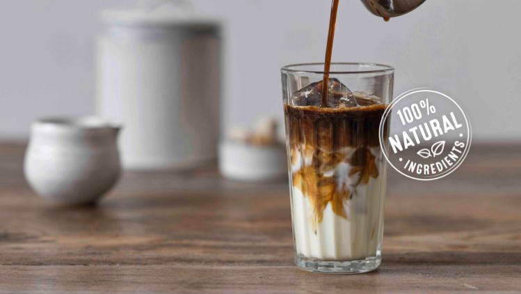 Coffee pouring in milk and 100% natural ingredients logo